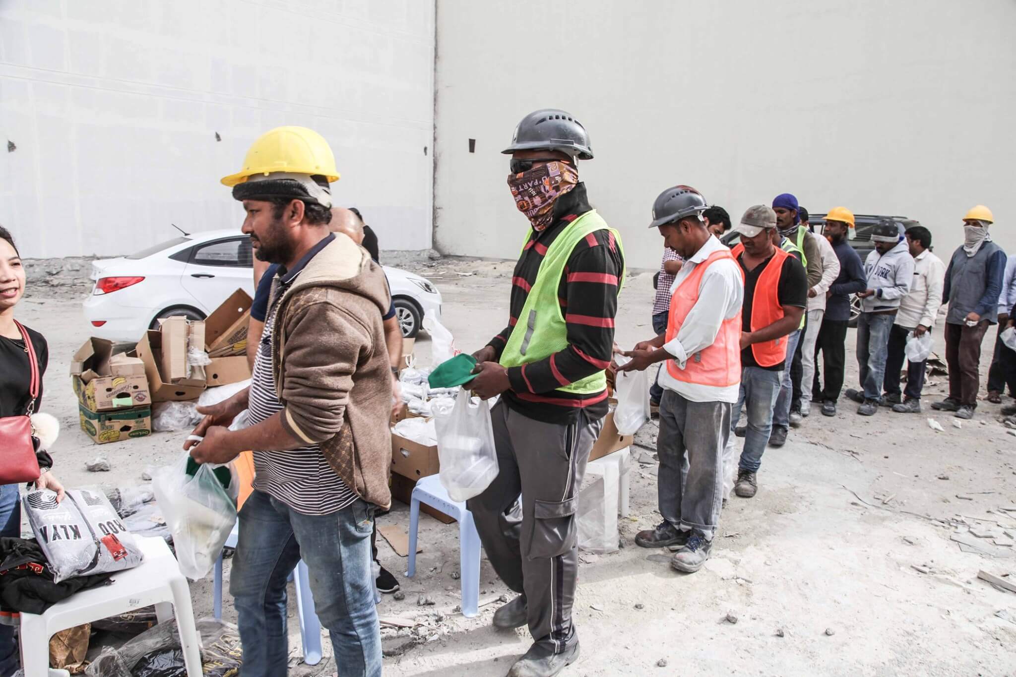 Workers in Bahrain standing in a line for their meal